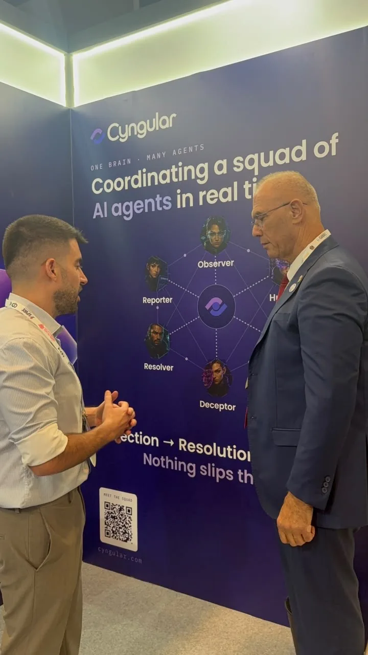 Israel's Ambassador to the UAE in conversation at the Cyngular stand, in front of the agent-mesh wall.
