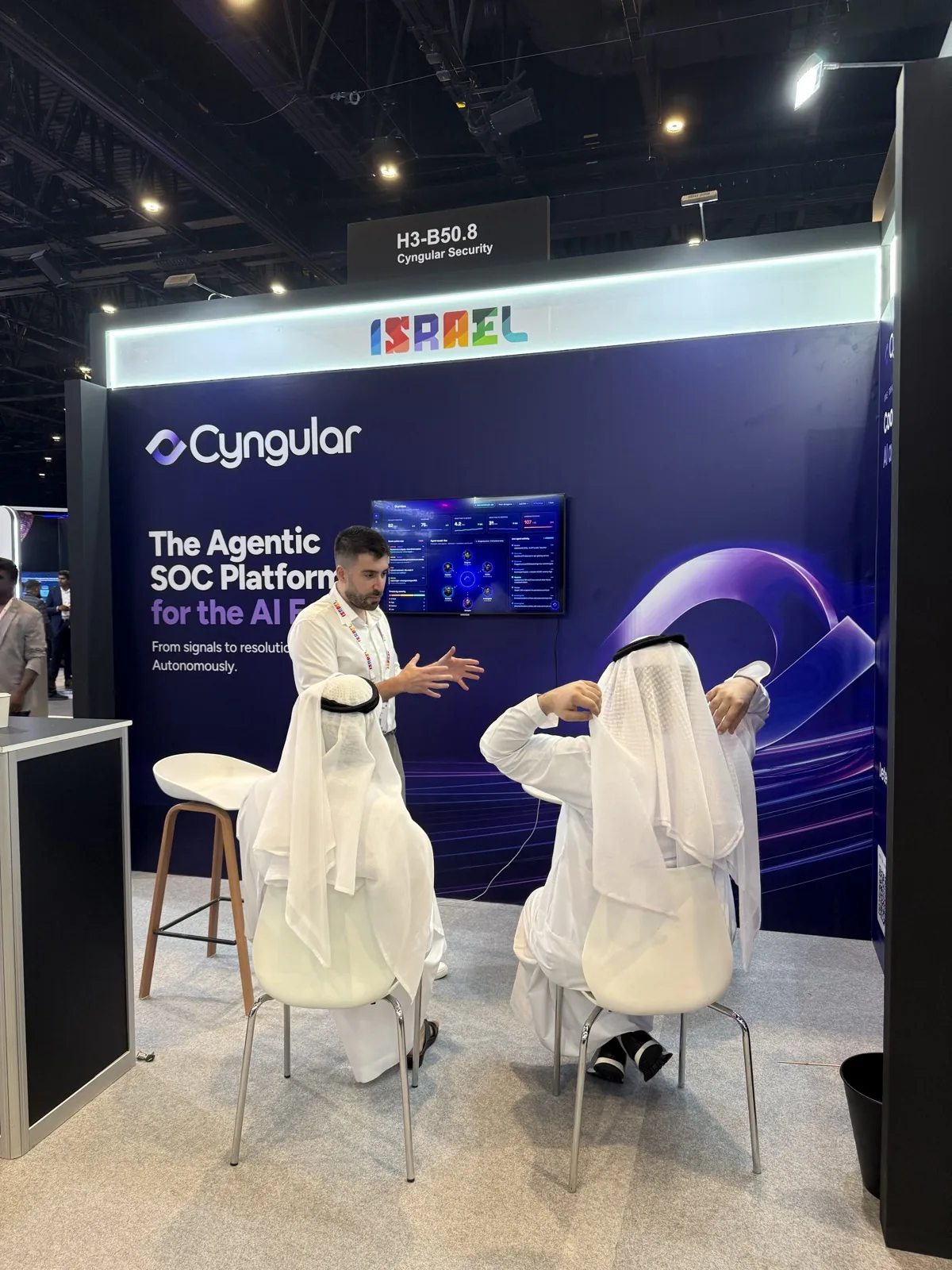 A Cyngular team member demoing the platform to two seated visitors.
