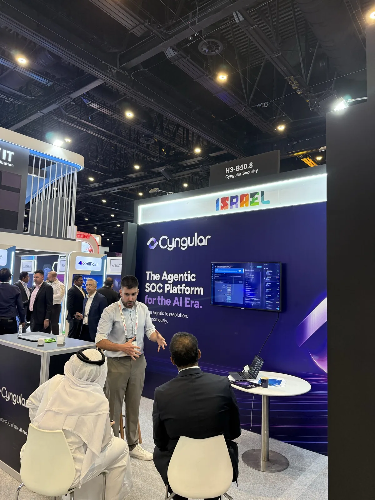 A Cyngular team member presenting the platform to seated visitors at the stand.